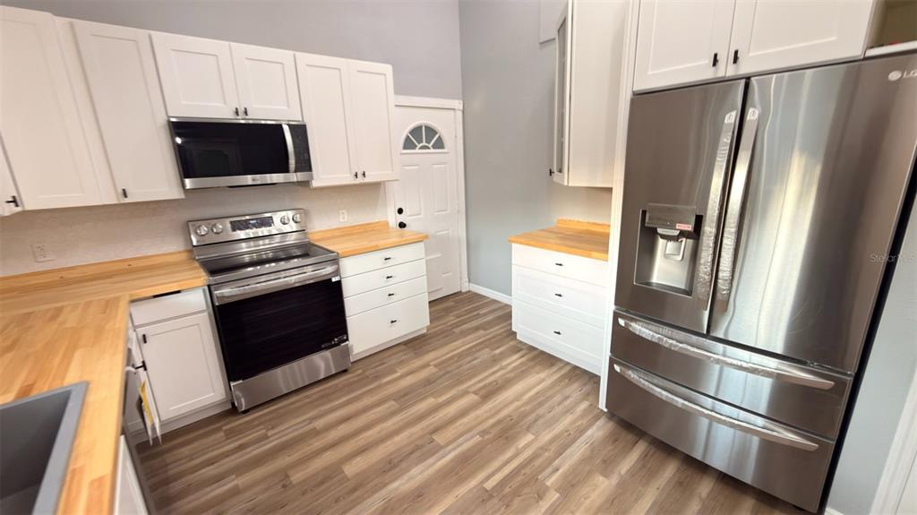 14740 Johns Road Dade City, FL 33525 - Photo 4 of 46 a kitchen with stainless steel appliances a refrigerator stove and sink