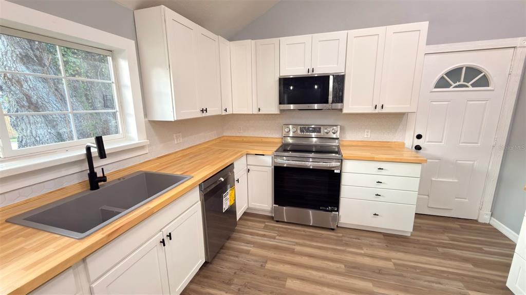 14740 Johns Road Dade City, FL 33525 - Photo 6 of 46 a kitchen with a sink stove and microwave