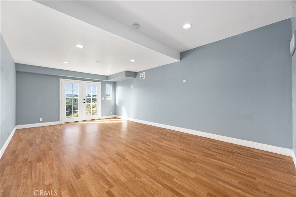 29300 Elkhorn Place Tehachapi, CA 93561 - Photo 24 of 47 a view of an empty room with wooden floor and a window