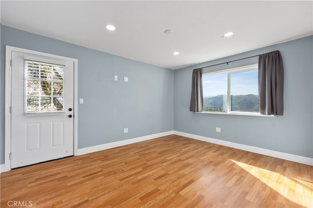 29300 Elkhorn Place Tehachapi, CA 93561 - Photo 27 of 47 a view of an empty room with wooden floor and a window