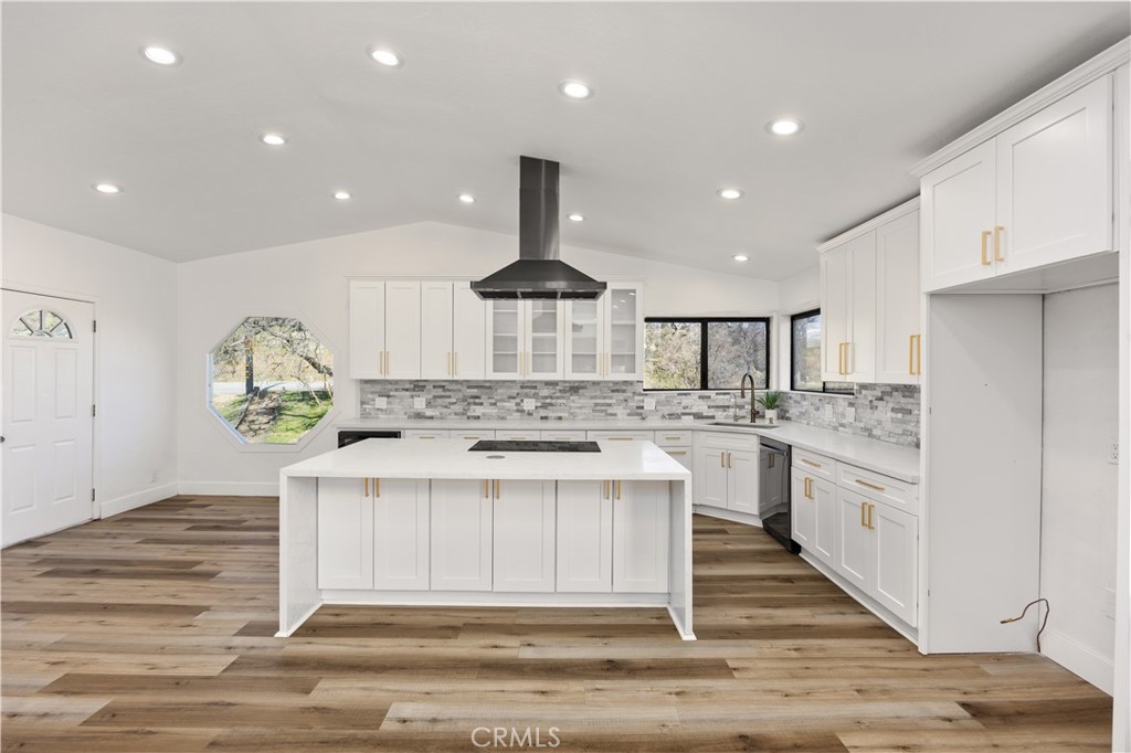 29300 Elkhorn Place Tehachapi, CA 93561 - Photo 8 of 47 a kitchen with stainless steel appliances granite countertop a stove top oven a sink dishwasher and white cabinets with wooden floor