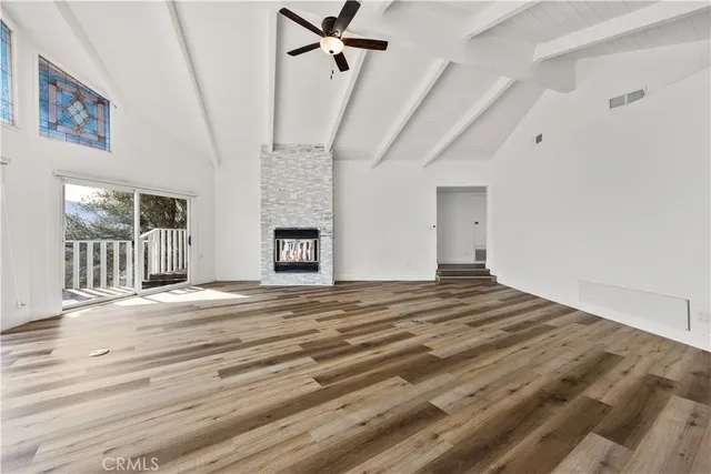 a view of empty room with wooden floor and fireplace