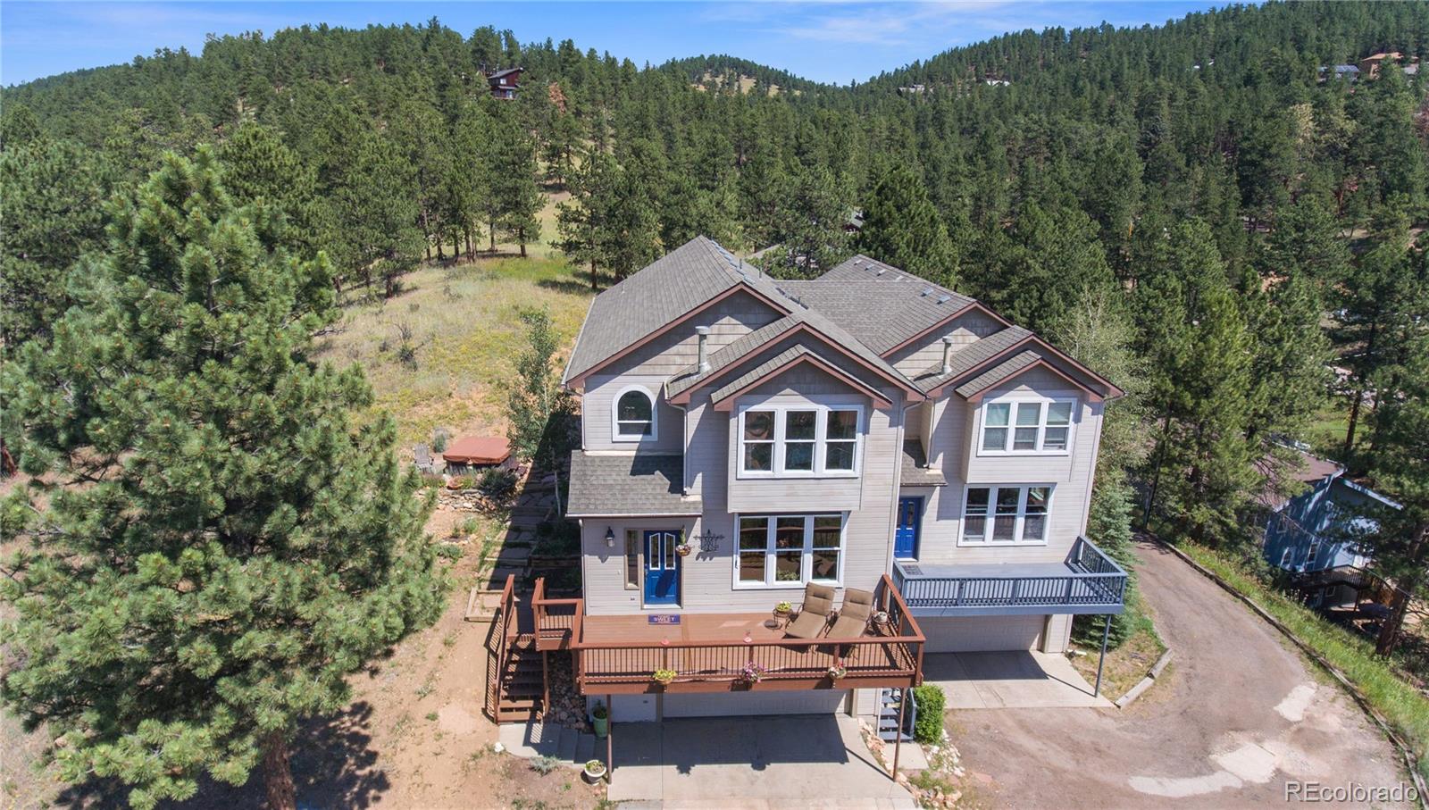 3345 Russell Gulch Road, Unit A Evergreen, CO 80439 - Photo 2 of 34 a front view of a house with a yard and mountain view