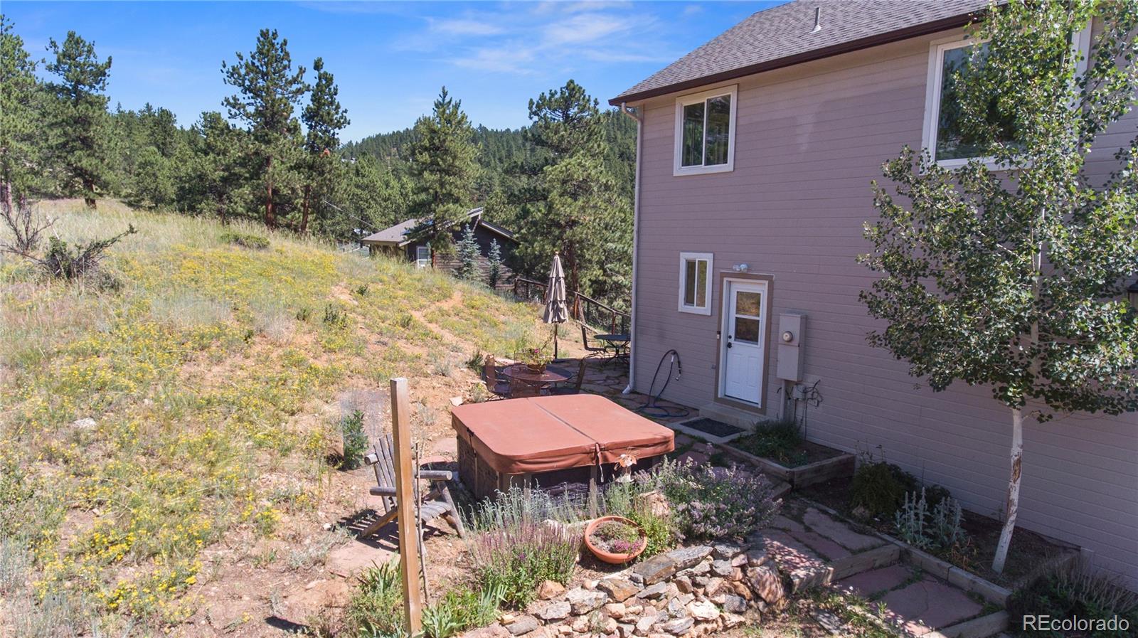3345 Russell Gulch Road, Unit A Evergreen, CO 80439 - Photo 33 of 34 a view of a backyard with table and chairs and a fire pit