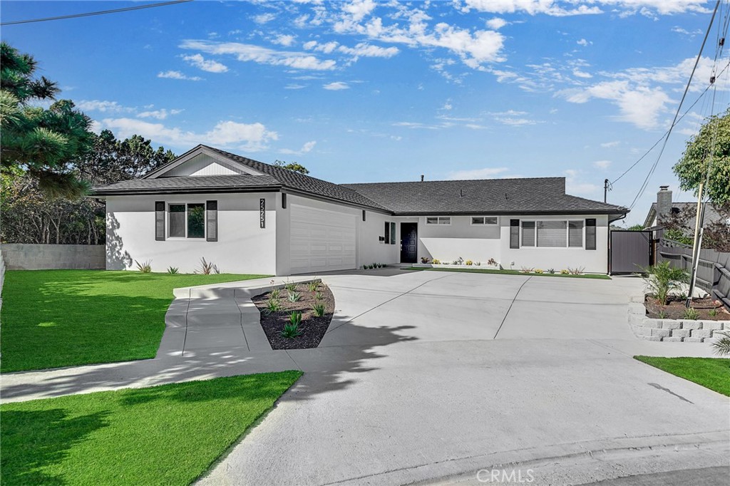 a front view of a house with a garden and trees