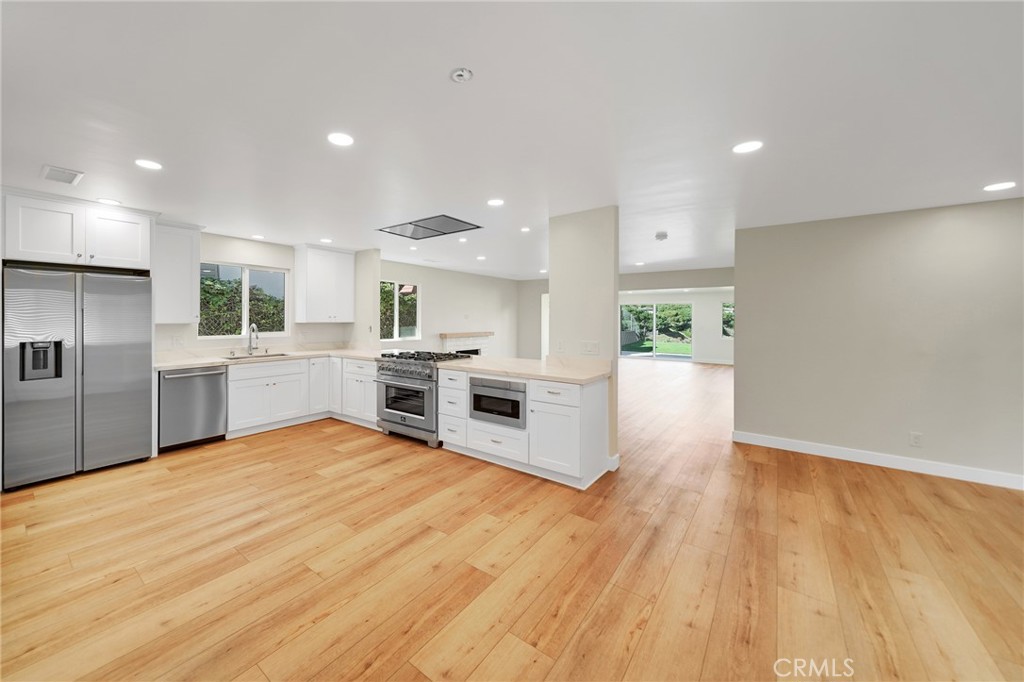 25251 Tuna Drive Dana Point, CA 92629 - Photo 11 of 30 a large kitchen with a white stove top oven and white cabinets