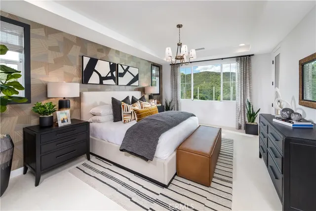 a spacious bedroom with a large bed and a chandelier