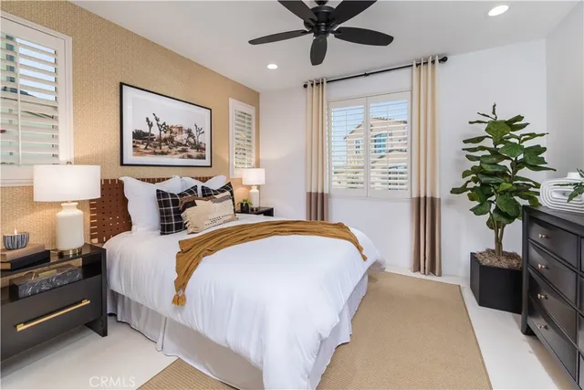 a spacious bedroom with bed and a potted plant