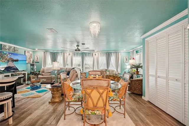 a view of a dining room with furniture a chandelier and wooden floor
