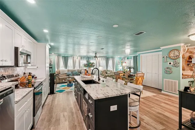 a kitchen with stainless steel appliances granite countertop a sink stove and wooden cabinets