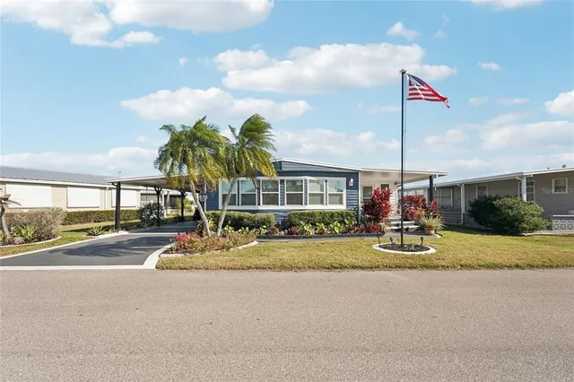 a front view of a house with a garden and trees
