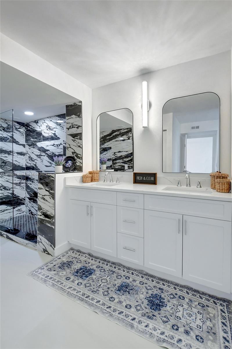 9264 Vista Del Lago, Unit E Boca Raton, FL 33428 - Photo 26 of 26 a bathroom with a double vanity sink and a mirror