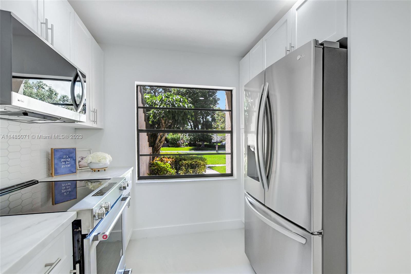 9264 Vista Del Lago, Unit E Boca Raton, FL 33428 - Photo 9 of 26 a kitchen with stainless steel appliances a refrigerator and a window