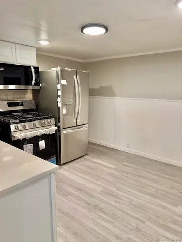 a kitchen with stainless steel appliances a refrigerator and a stove top oven