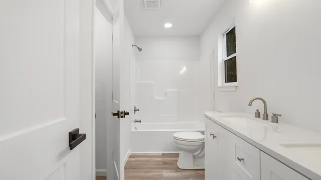 a bathroom with a toilet sink a mirror and shower