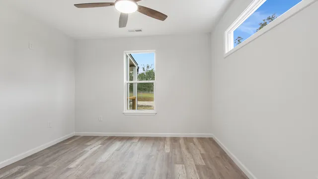 an empty room with a window and wooden floor