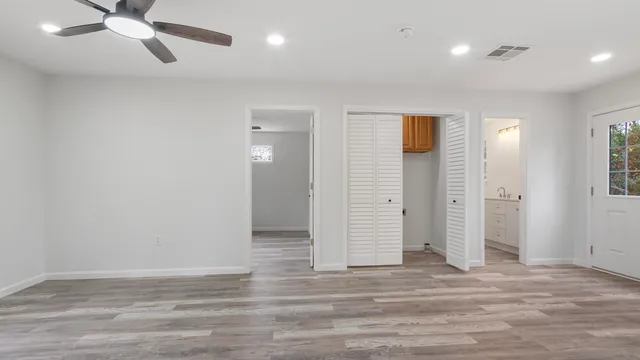 an empty room with wooden floor and windows