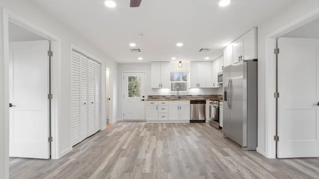 a kitchen with stainless steel appliances kitchen island hardwood floor sink and stove