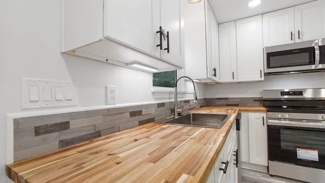 a kitchen with stainless steel appliances granite countertop a sink a stove and a microwave