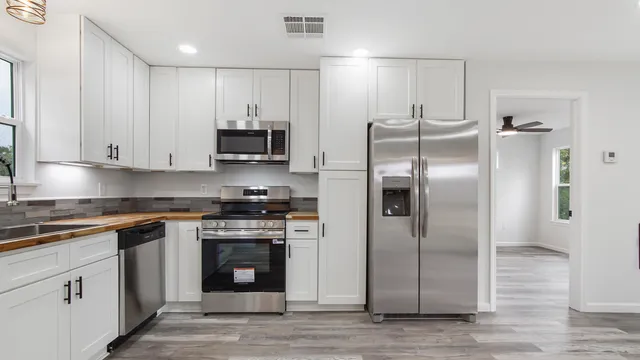 a kitchen with stainless steel appliances granite countertop a stove and a refrigerator