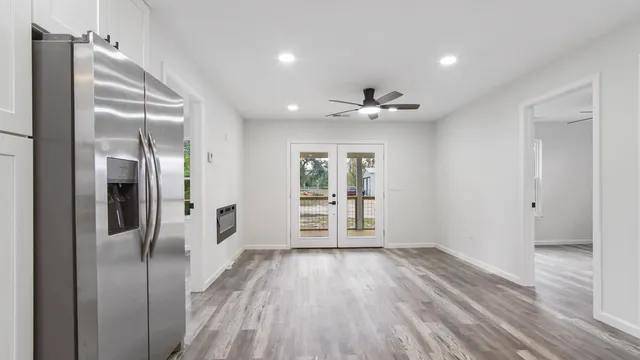 a view of a hallway with wooden floor and a bathroom