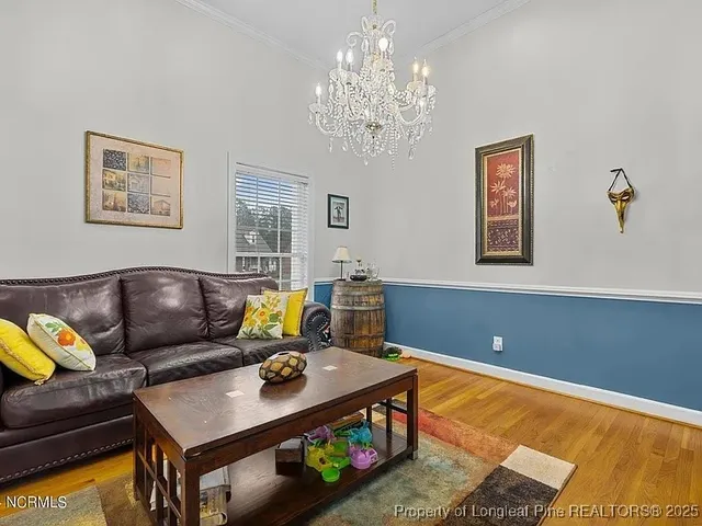 a living room with furniture and a chandelier