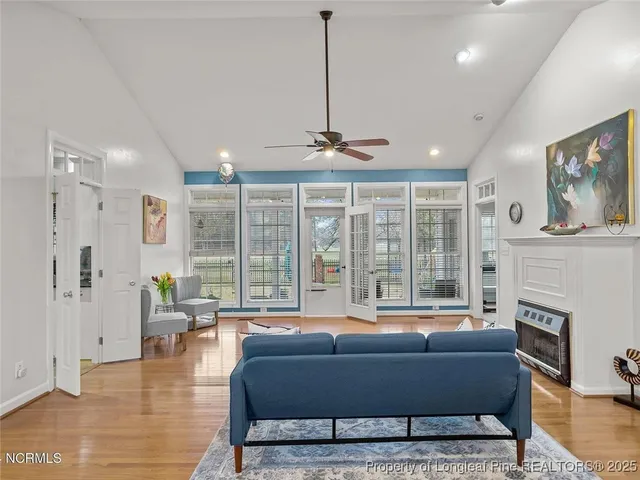 a living room with furniture a large window and a dining table