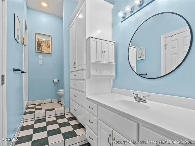 a bathroom with a sink a toilet and a mirror