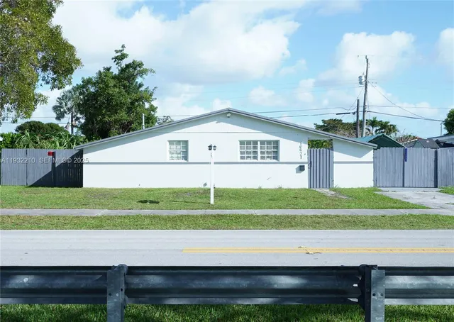 a white bench sitting in front of a house