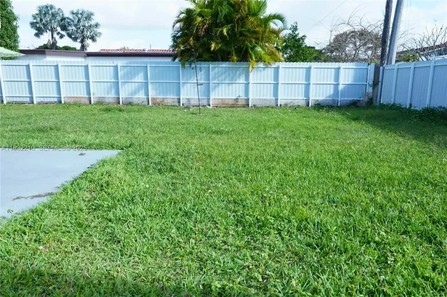 a view of a backyard with a fence and plants