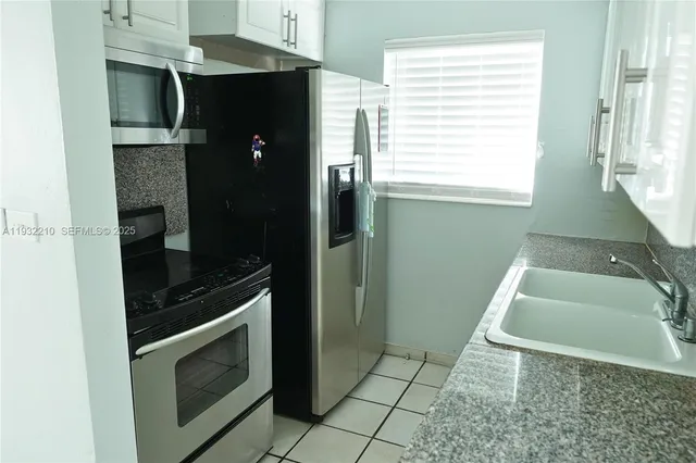 a kitchen with a sink and a stove top oven