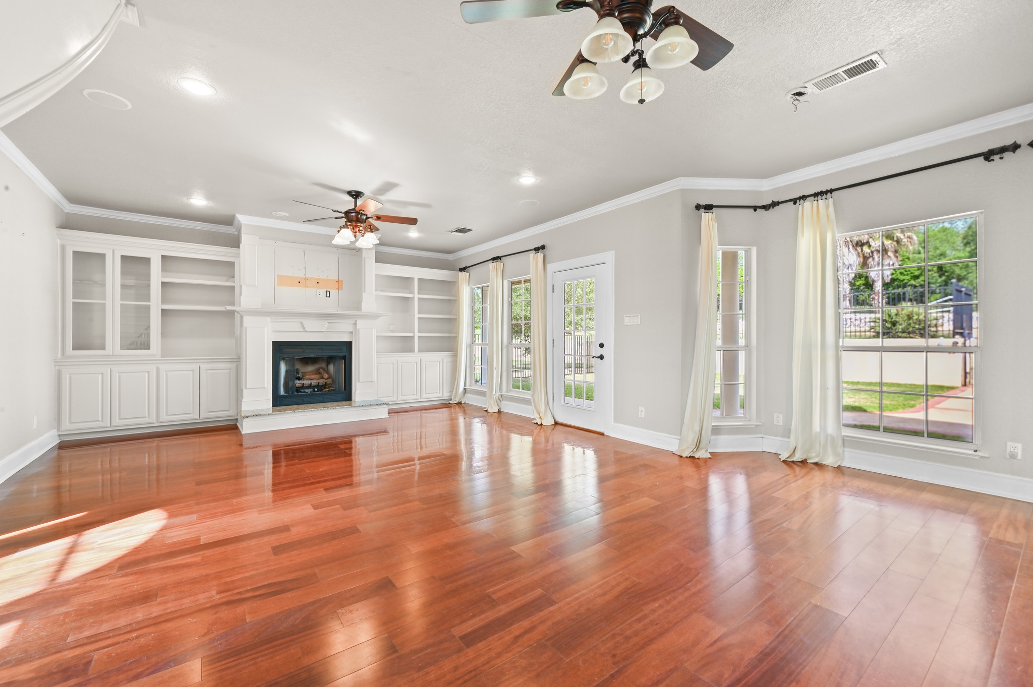 1175 Southern Way Luling, TX 78648 - Photo 17 of 40 Rich hardwood floors complement a fireplace flanked by built-in shelving, perfect for quiet evenings or entertaining.