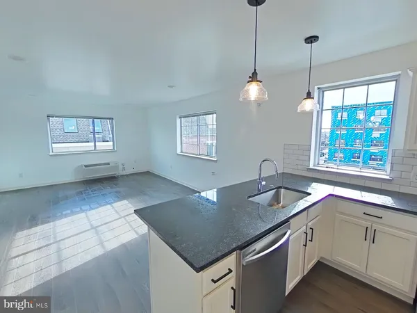 a kitchen with stainless steel appliances granite countertop a sink a stove a dining table and chairs