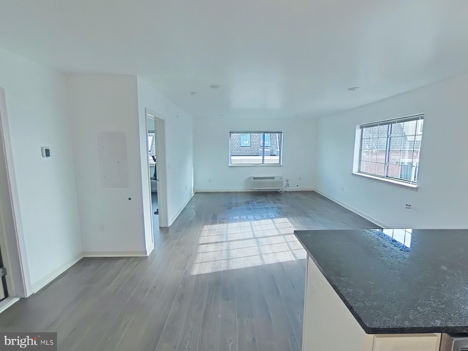 6649 Ridge Avenue, Unit C104 Philadelphia, PA 19128 - Photo 2 of 7 an empty room with wooden floor and windows