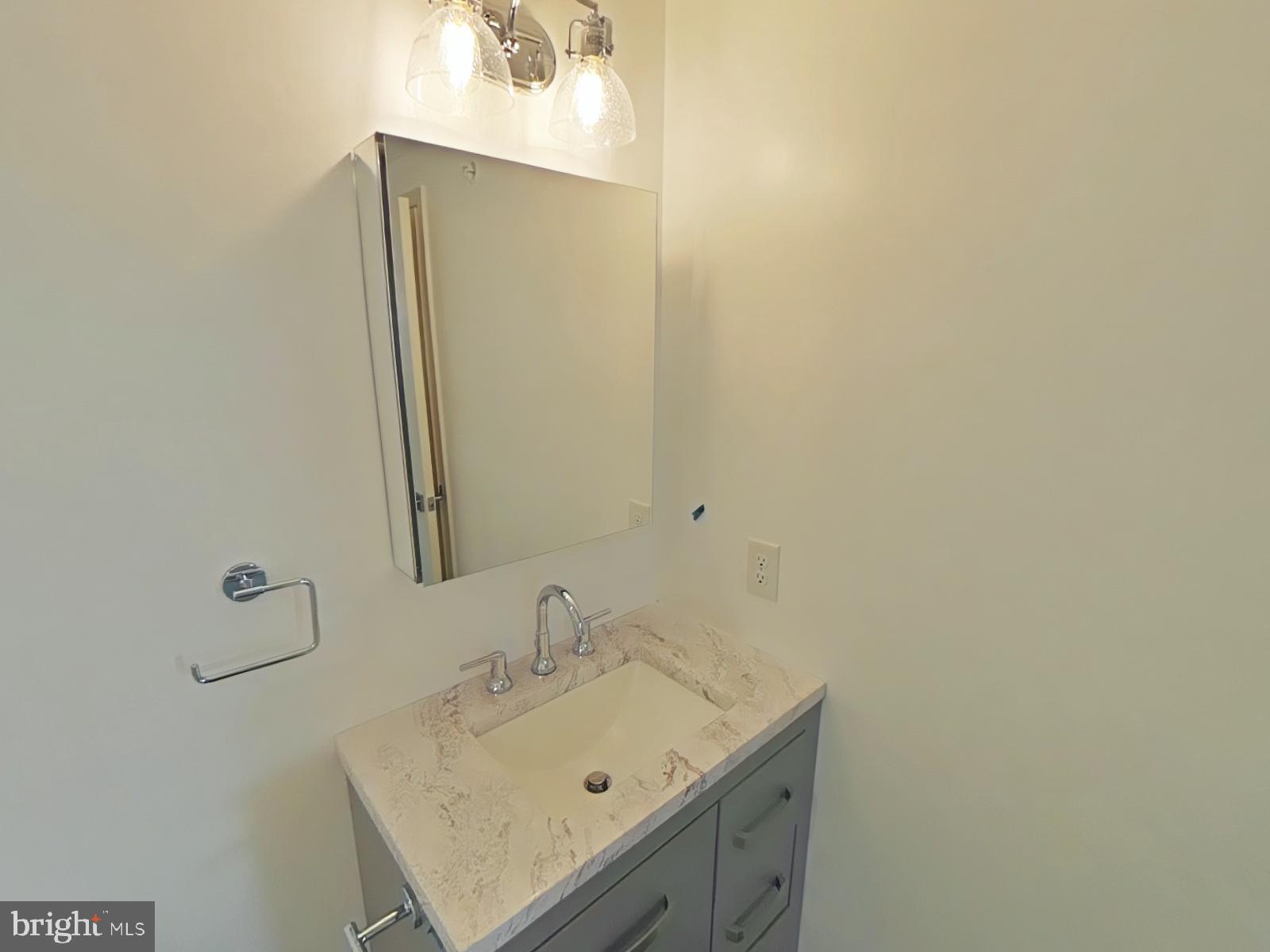 6649 Ridge Avenue, Unit C104 Philadelphia, PA 19128 - Photo 5 of 7 a bathroom with a sink and a mirror
