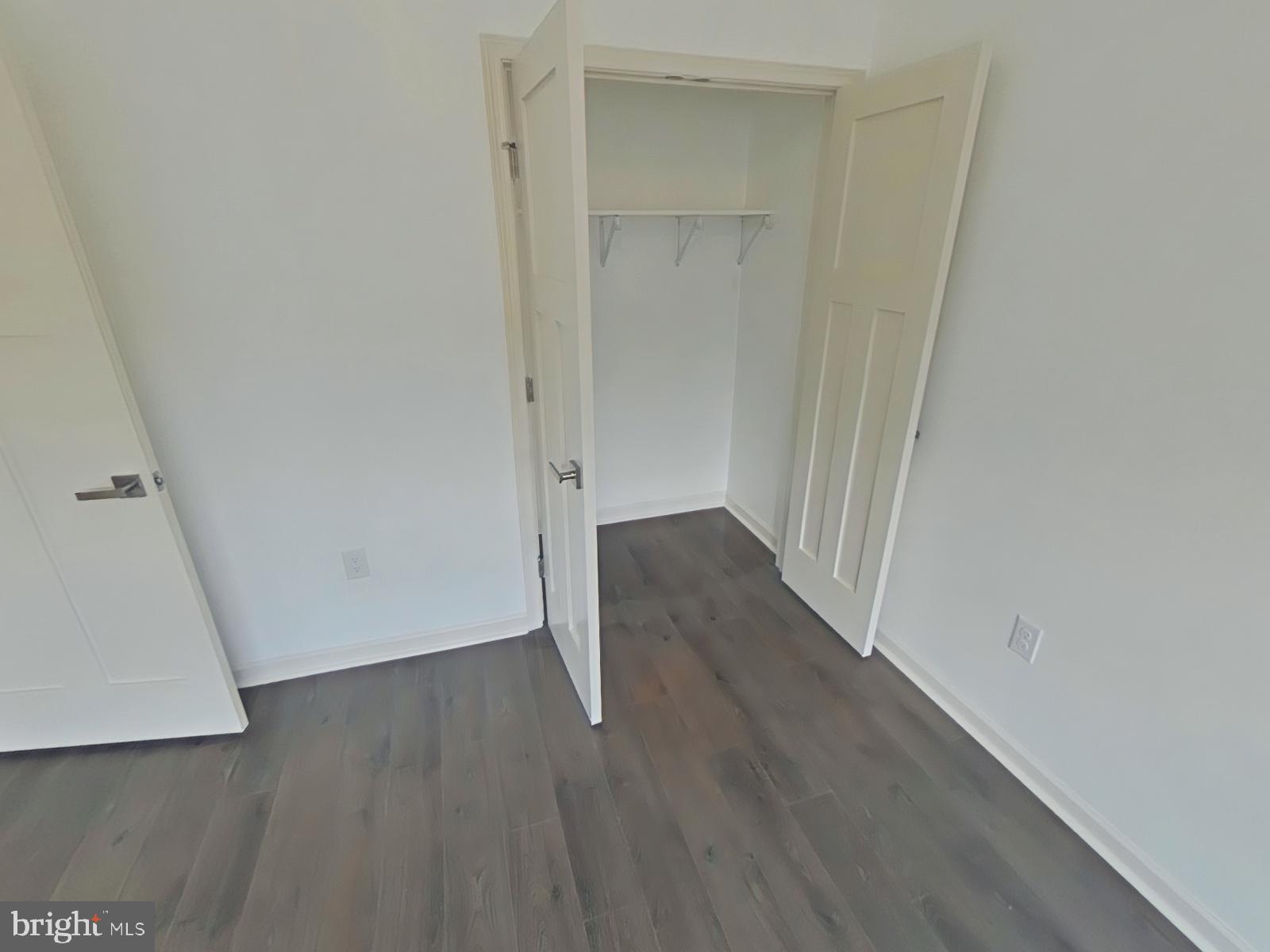 6649 Ridge Avenue, Unit C104 Philadelphia, PA 19128 - Photo 6 of 7 an empty room with wooden floor and white walls