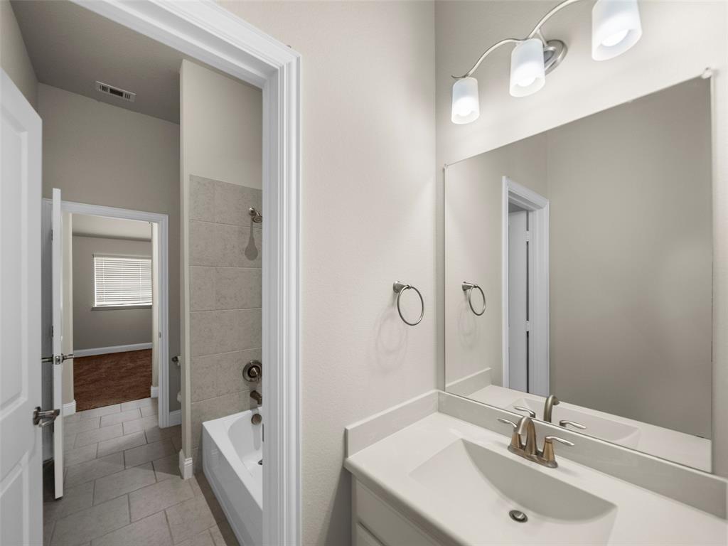3044 Bold Ruler Road Celina, TX 75009 - Photo 17 of 36 a bathroom with a sink and a mirror