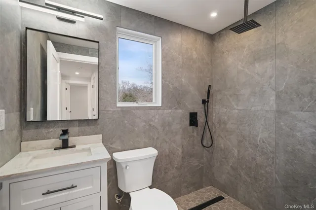 a bathroom with a toilet sink vanity and mirror