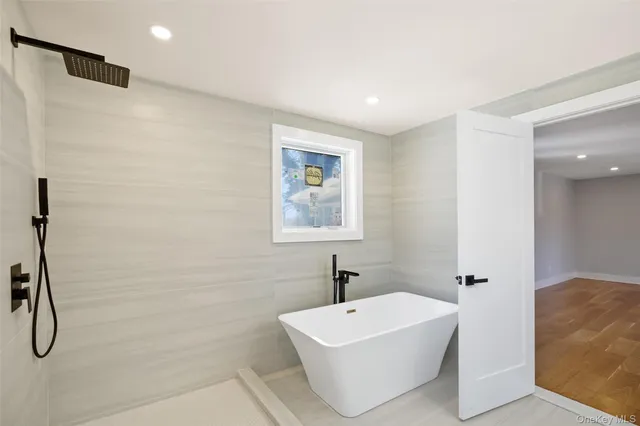 a white bath tub sitting next to a white sink and a shower