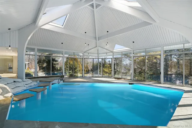 a swimming pool with large glass windows and painted walls