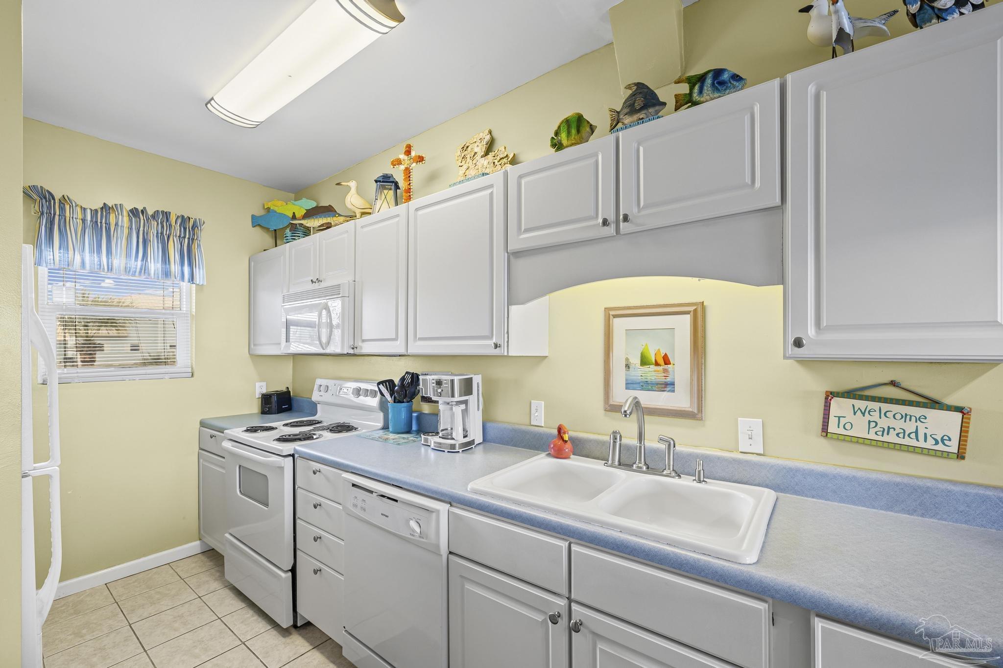 1150 Fort Pickens Road, Unit A1 Pensacola Beach, FL 32561 - Photo 18 of 45 a kitchen with cabinets appliances a sink and a counter top space