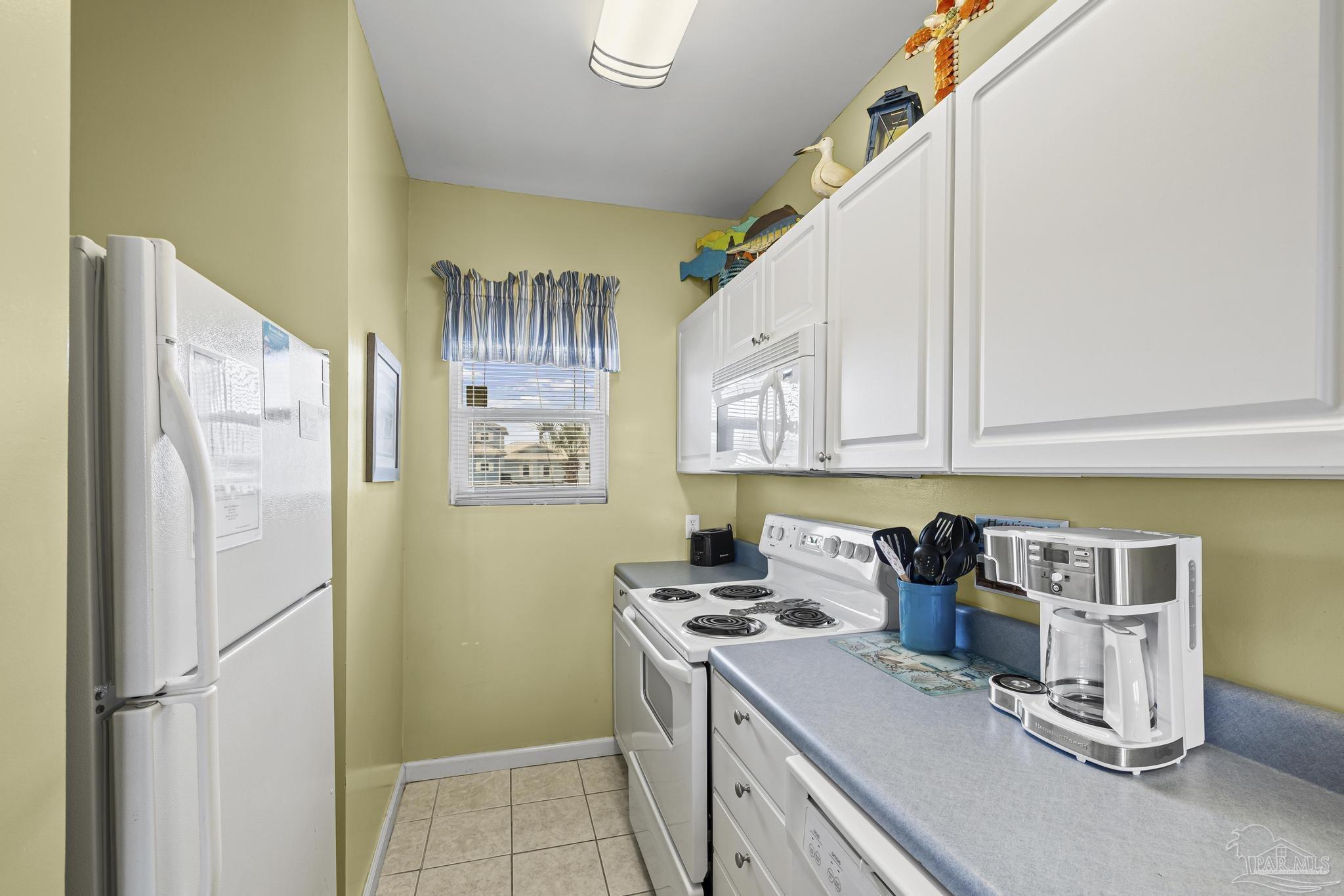 1150 Fort Pickens Road, Unit A1 Pensacola Beach, FL 32561 - Photo 19 of 45 a kitchen with refrigerator and cabinets