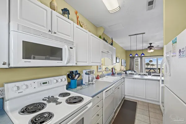 a dining hall with a sink dishwasher and a refrigerator