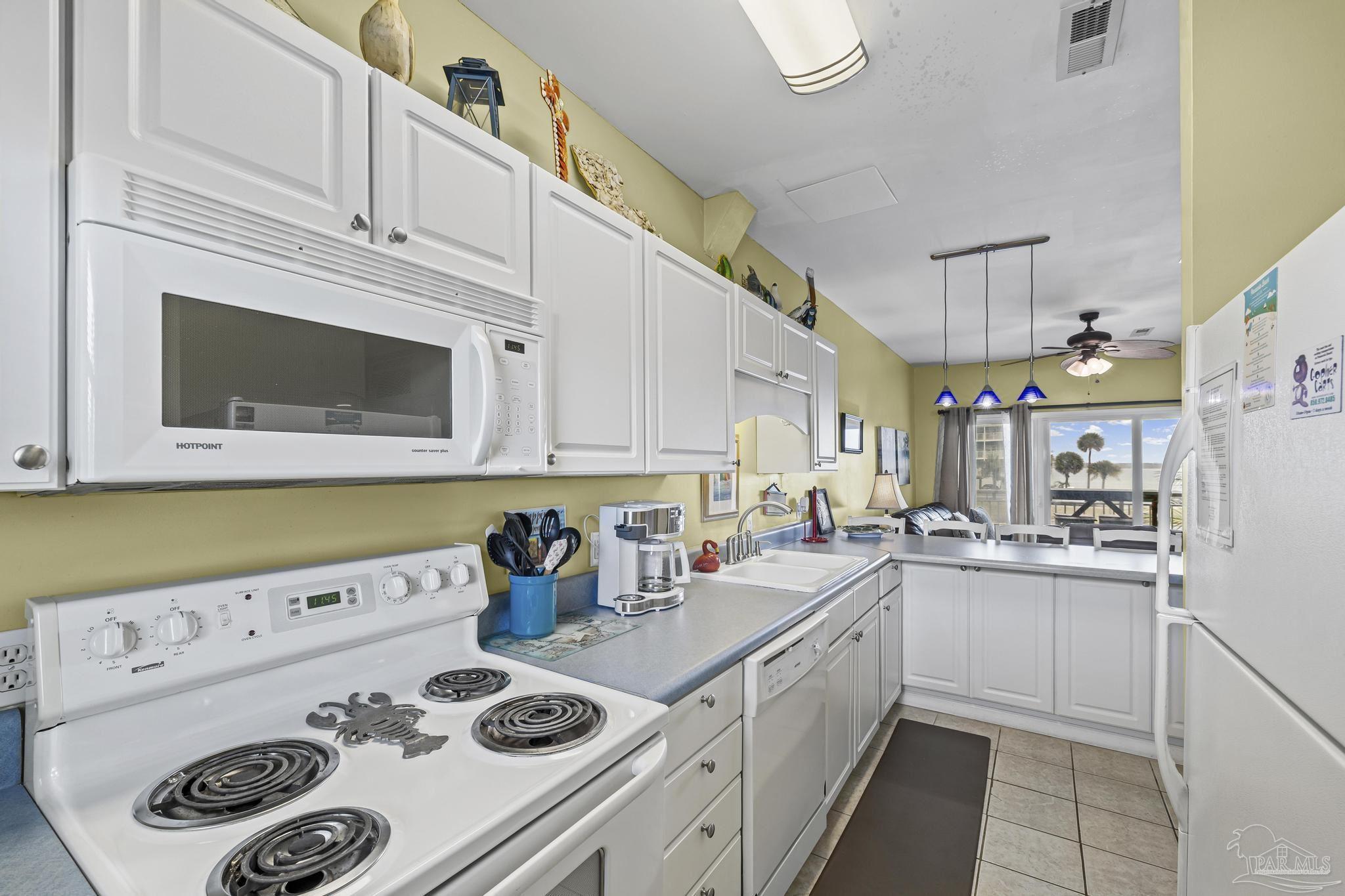1150 Fort Pickens Road, Unit A1 Pensacola Beach, FL 32561 - Photo 20 of 45 a kitchen with a sink a stove and cabinets