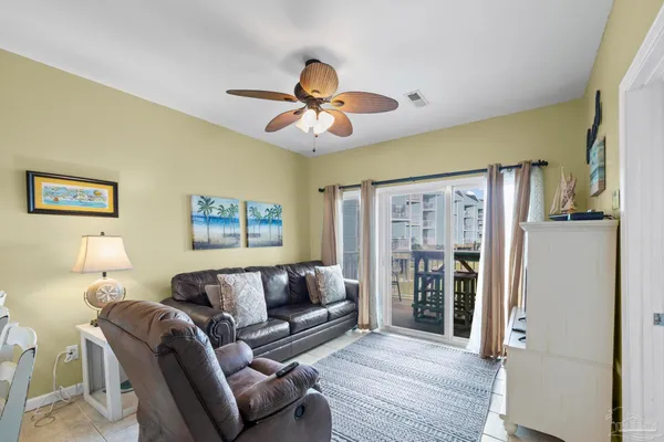 a living room with furniture ceiling fan and a flat screen tv