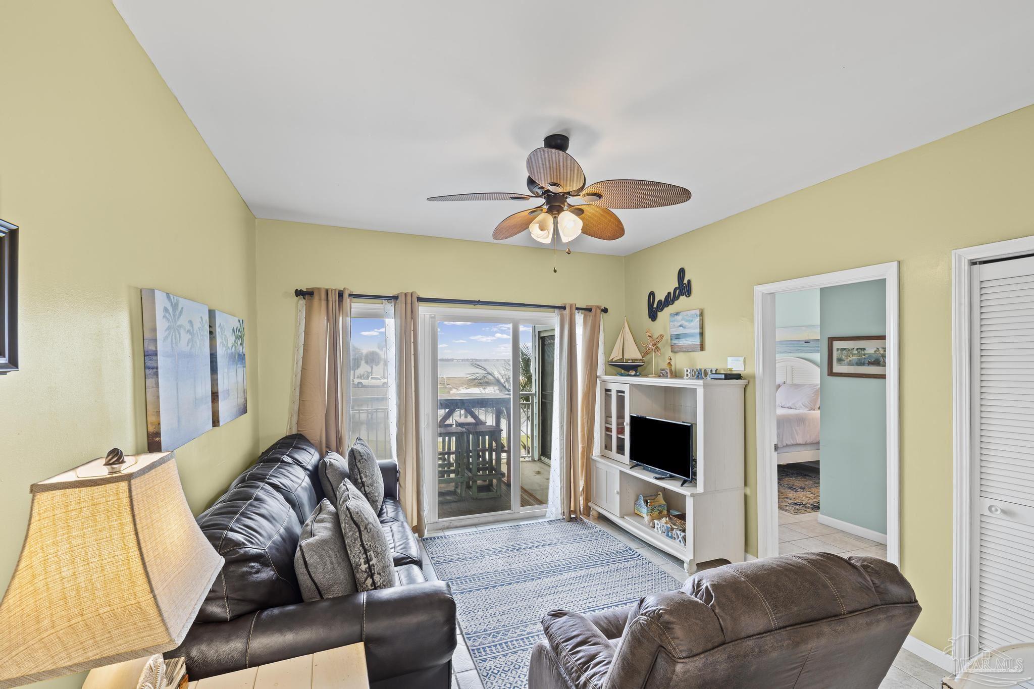 1150 Fort Pickens Road, Unit A1 Pensacola Beach, FL 32561 - Photo 23 of 45 a living room with furniture ceiling fan and a flat screen tv