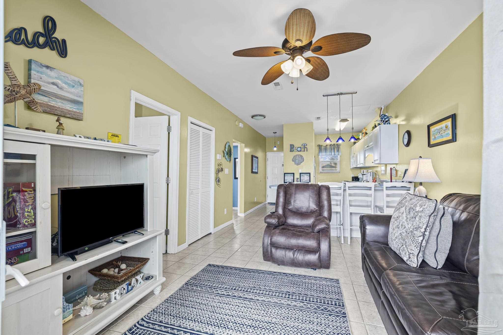 1150 Fort Pickens Road, Unit A1 Pensacola Beach, FL 32561 - Photo 25 of 45 a living room with furniture a flat screen tv and a fireplace