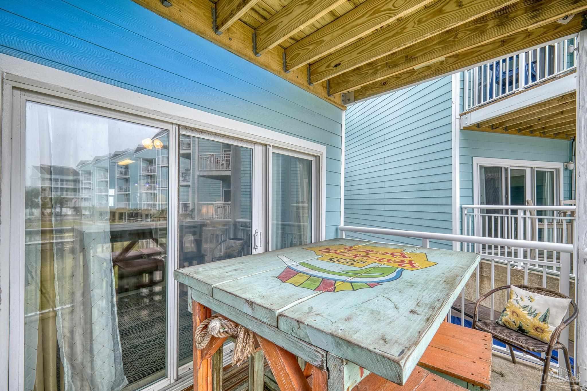 1150 Fort Pickens Road, Unit A1 Pensacola Beach, FL 32561 - Photo 30 of 45 a balcony view with a table and chairs