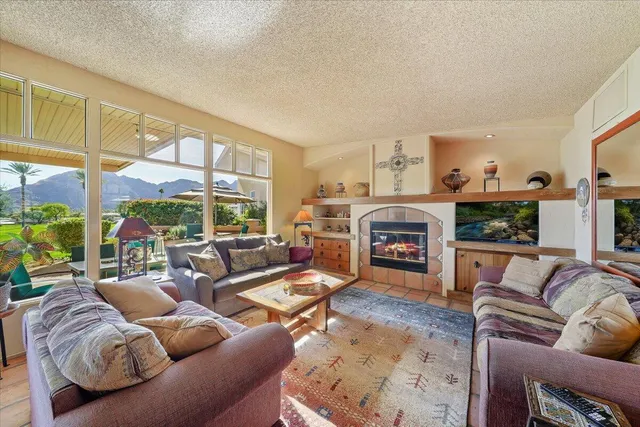 a living room with furniture large windows and a fireplace