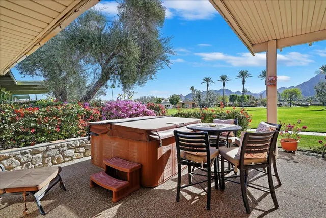 a view of a patio with a dining table and chairs under an umbrella